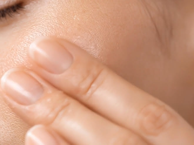 Nahaufnahme: Fingerspitzen berühren die glatte, elastische Haut einer Wange